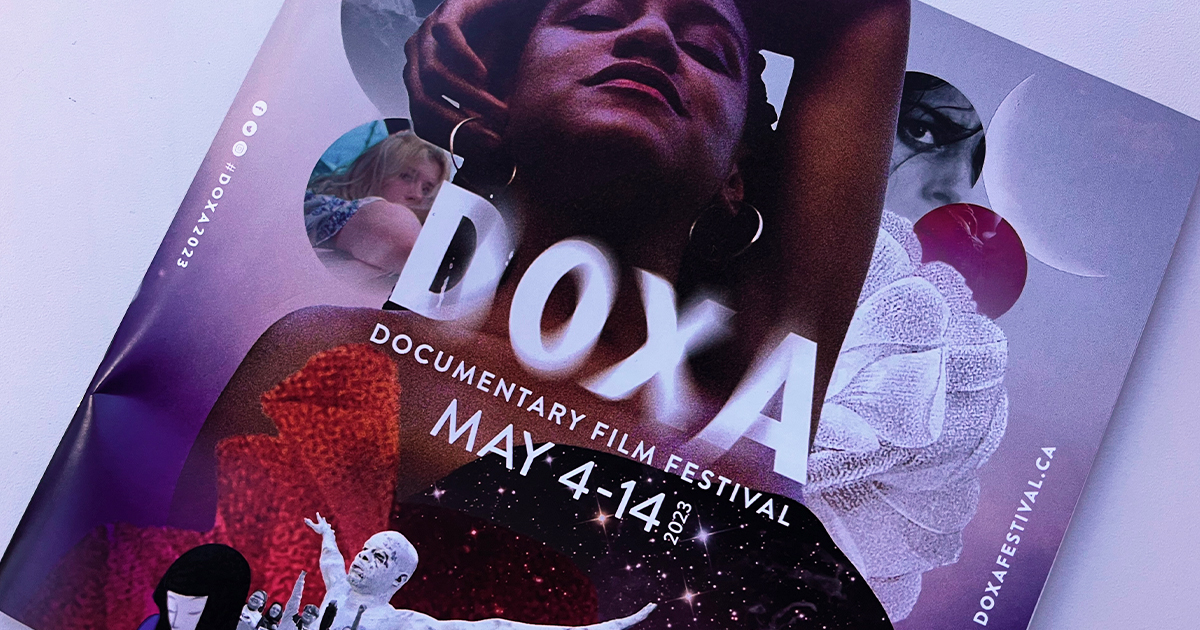 DOXA 2023 Program Book with key art against a white tabletop