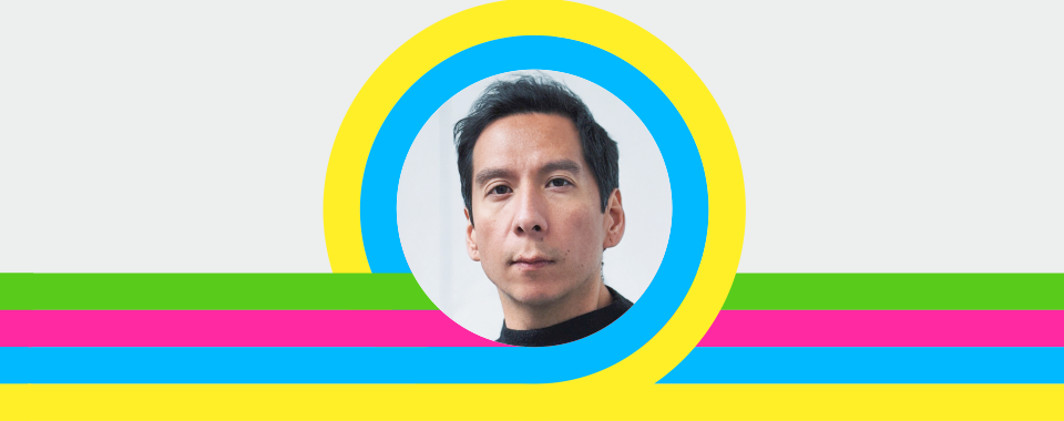 Front-facing portrait of a man with short dark hair and neutral expression, inside a circular frame with vibrant yellow and blue rings, set on a gray background with horizontal green, pink, and blue stripes; clean modern branding graphic.